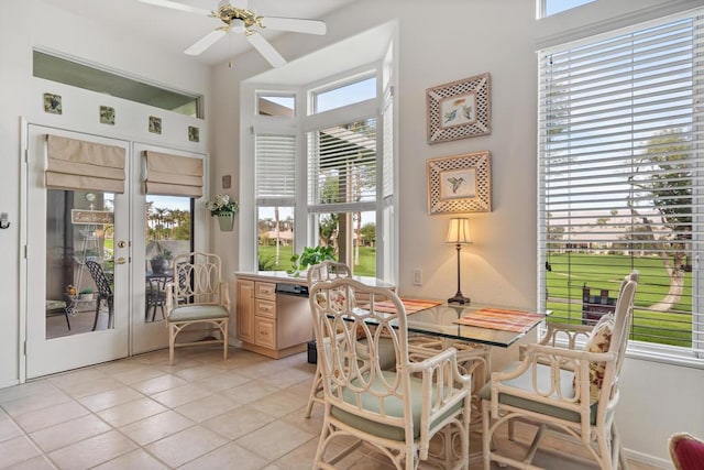 tiled dining room featuring ceiling fan and french doors