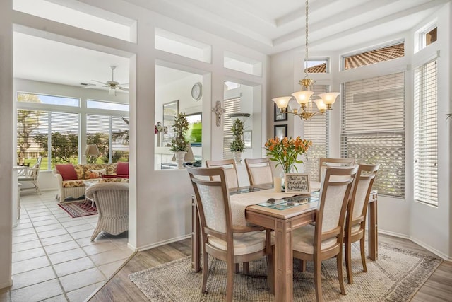 dining area featuring light wood-type flooring and ceiling fan with notable chandelier