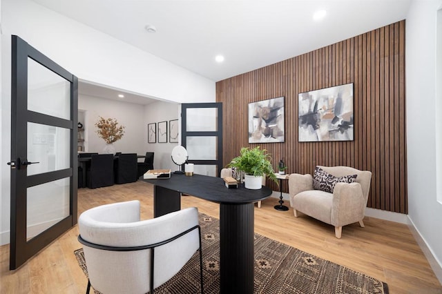 office space featuring light wood-type flooring and wood walls