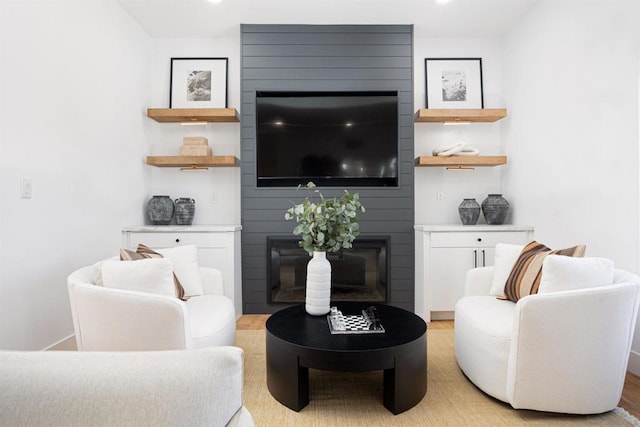 living room with light wood-type flooring and a large fireplace