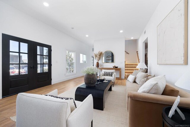 living room featuring french doors and light hardwood / wood-style flooring