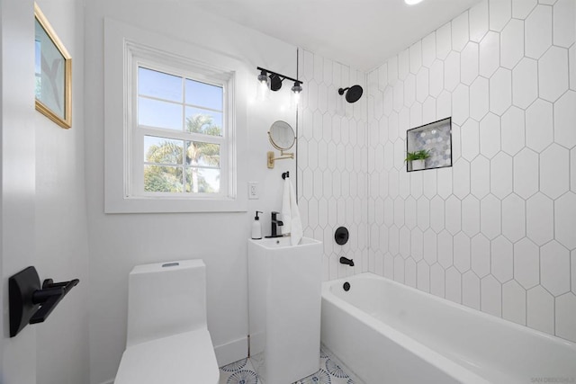 bathroom featuring toilet, tiled shower / bath, and tile patterned flooring