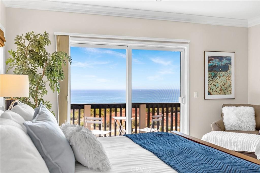 bedroom featuring ornamental molding and a water view