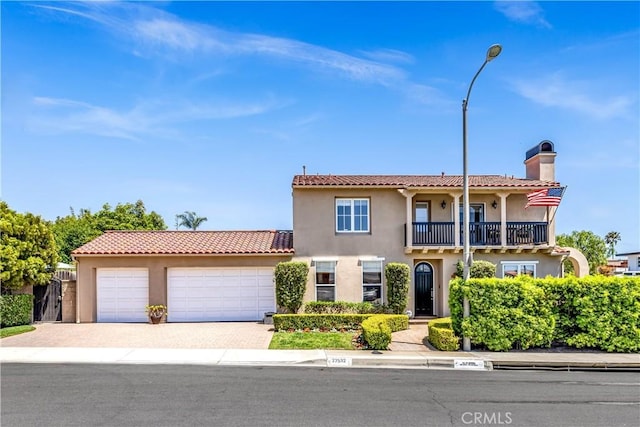 mediterranean / spanish-style house with a garage and a balcony