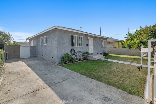 ranch-style home with a front lawn