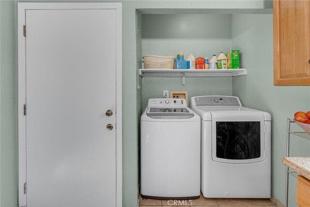 laundry area with light tile patterned floors and washer and clothes dryer