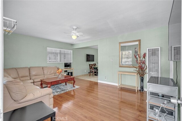 living room featuring ceiling fan and hardwood / wood-style flooring