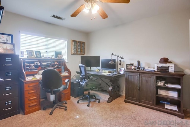 carpeted home office featuring ceiling fan