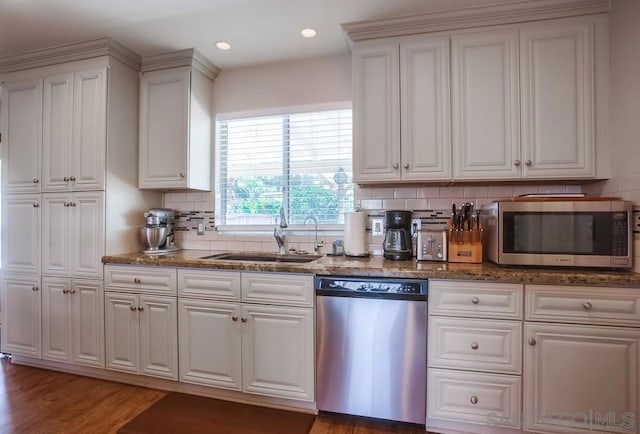 kitchen featuring tasteful backsplash, dark stone countertops, sink, appliances with stainless steel finishes, and white cabinets