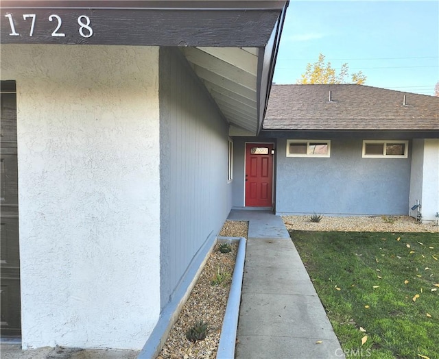 view of exterior entry featuring a yard