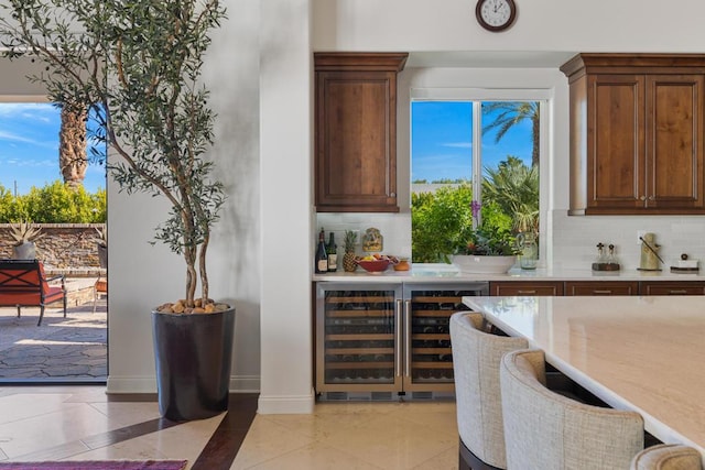 bar featuring light tile patterned floors, backsplash, and beverage cooler