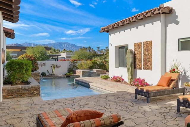 view of pool featuring an in ground hot tub, a mountain view, pool water feature, and a patio area