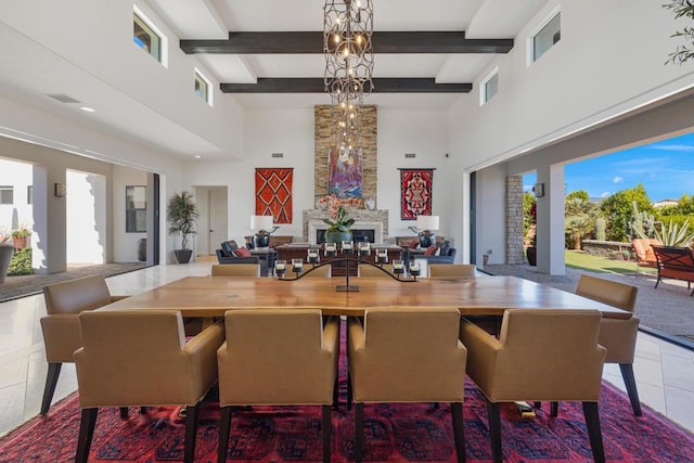 dining space featuring beamed ceiling, a healthy amount of sunlight, tile patterned flooring, and a notable chandelier