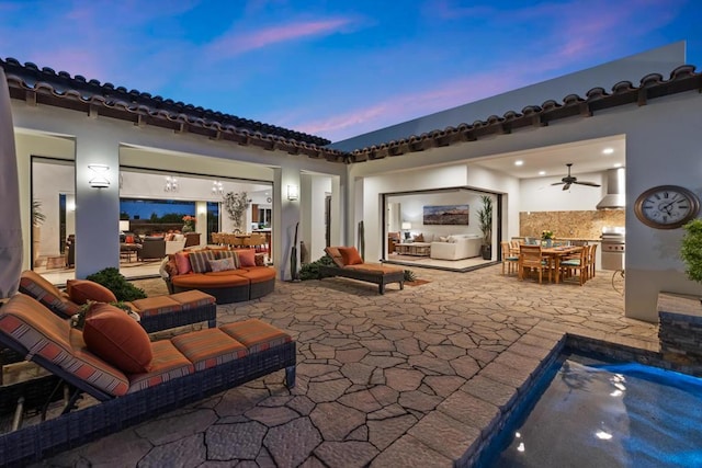 patio terrace at dusk with outdoor lounge area and ceiling fan