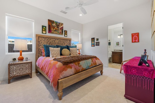 carpeted bedroom with connected bathroom and ceiling fan