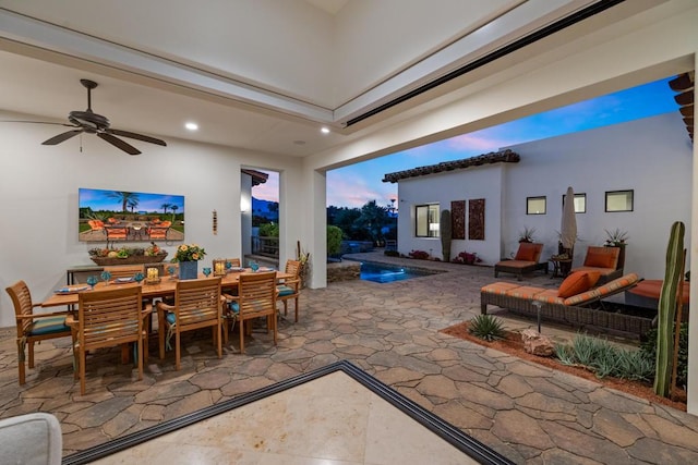 patio terrace at dusk featuring an outdoor hangout area, pool water feature, and ceiling fan