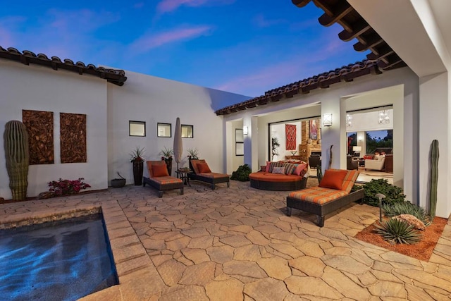 patio terrace at dusk featuring a swimming pool and an outdoor hangout area