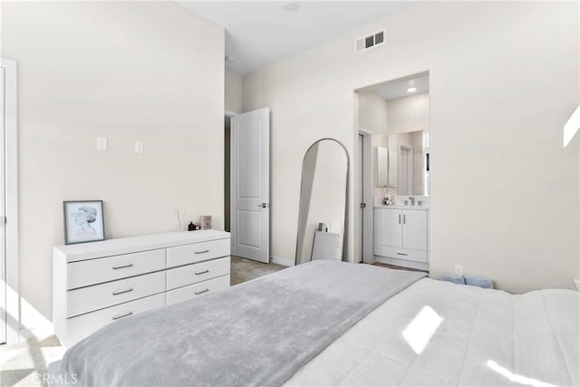 bedroom featuring light carpet and connected bathroom