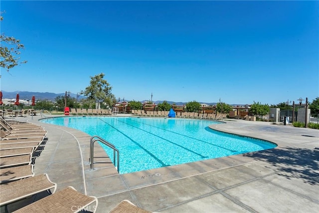 view of swimming pool with a patio area and a mountain view