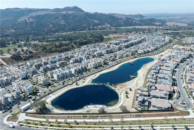 drone / aerial view featuring a water and mountain view