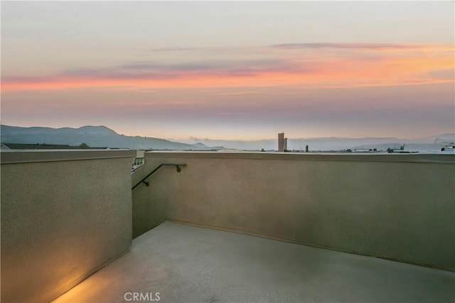 patio terrace at dusk featuring a mountain view