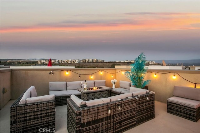 patio terrace at dusk featuring an outdoor living space with a fire pit