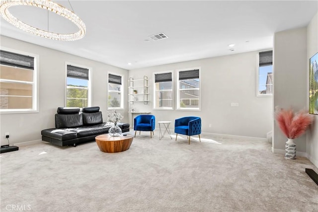 carpeted living room with a chandelier