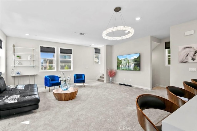 carpeted living room featuring an inviting chandelier