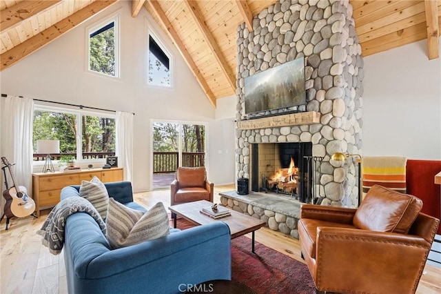 living room featuring a stone fireplace, wooden ceiling, high vaulted ceiling, light hardwood / wood-style flooring, and beamed ceiling