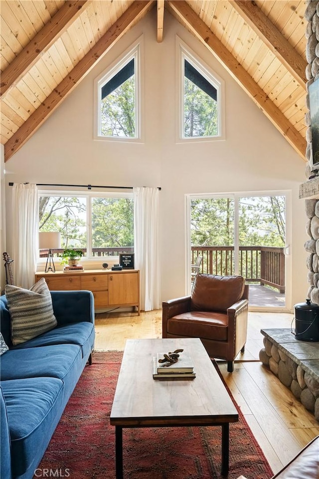 living room with high vaulted ceiling, light hardwood / wood-style flooring, and beam ceiling