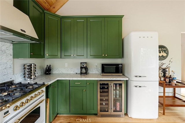 kitchen featuring range, extractor fan, white refrigerator, wine cooler, and green cabinets