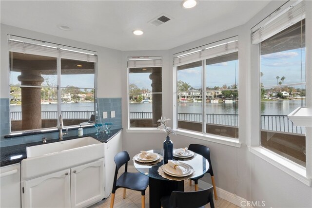 sunroom featuring sink and a water view