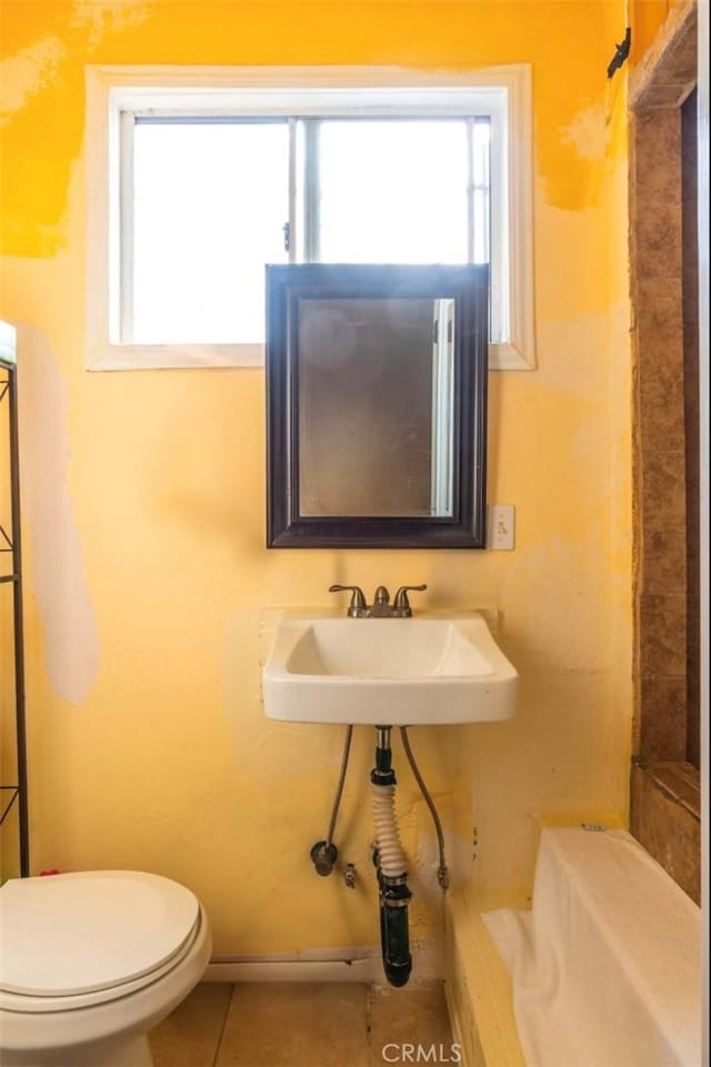 bathroom with toilet, tile patterned floors, and sink