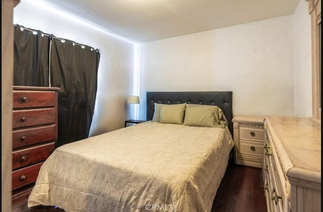 bedroom with dark hardwood / wood-style flooring