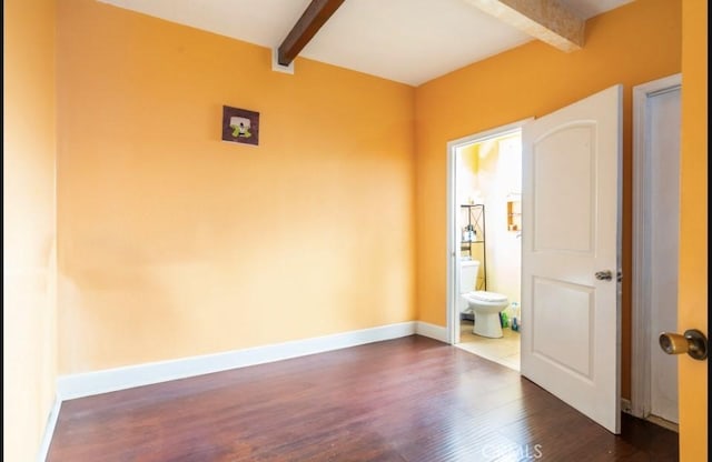 empty room with dark hardwood / wood-style flooring and beam ceiling