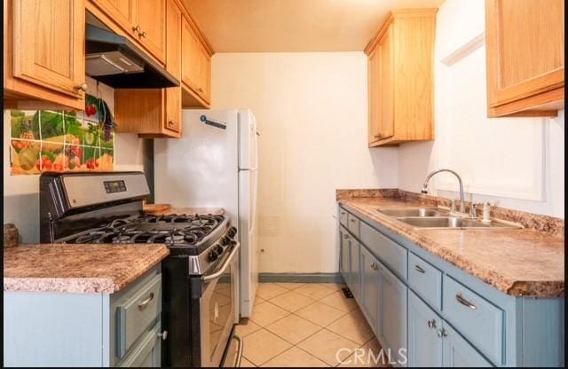 kitchen with gray cabinets, sink, light brown cabinetry, and stainless steel gas range oven