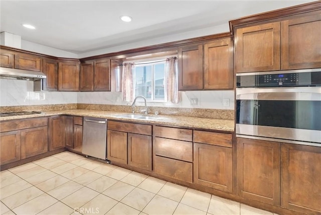 kitchen with light tile patterned floors, appliances with stainless steel finishes, light stone counters, and sink