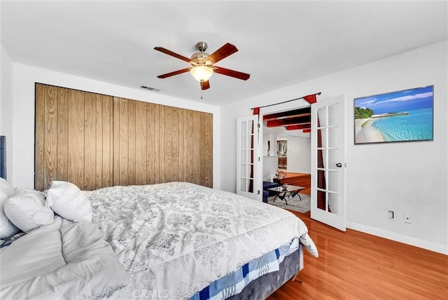 bedroom featuring ceiling fan, french doors, and hardwood / wood-style floors