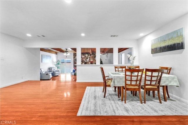 dining space with ceiling fan and light wood-type flooring