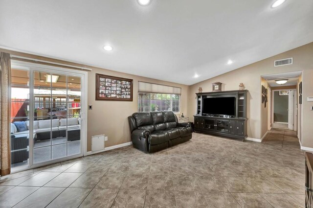 living room with lofted ceiling and tile patterned flooring