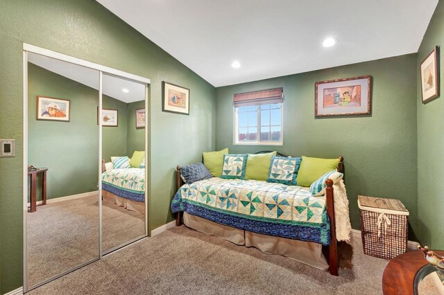 carpeted bedroom featuring lofted ceiling and a closet