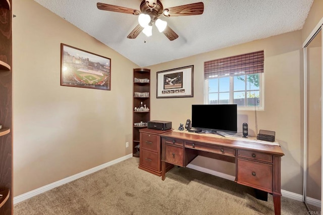 carpeted office space with ceiling fan, vaulted ceiling, and a textured ceiling