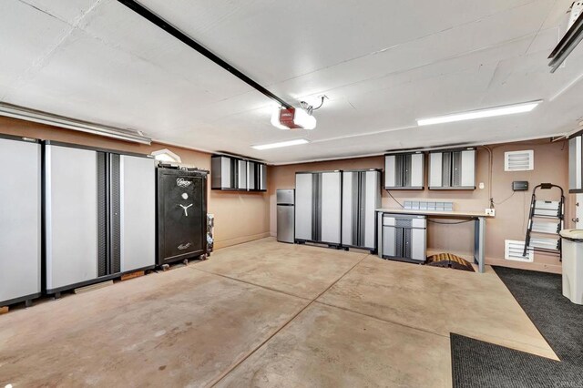 garage featuring a garage door opener and stainless steel refrigerator