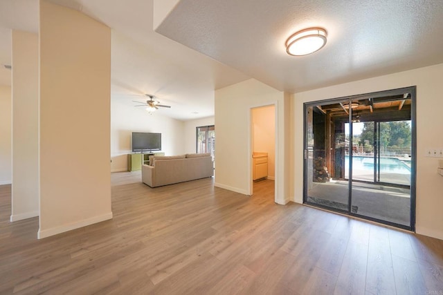 empty room featuring hardwood / wood-style floors, a textured ceiling, a wealth of natural light, and ceiling fan