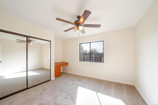 unfurnished bedroom with ceiling fan, light colored carpet, and a closet