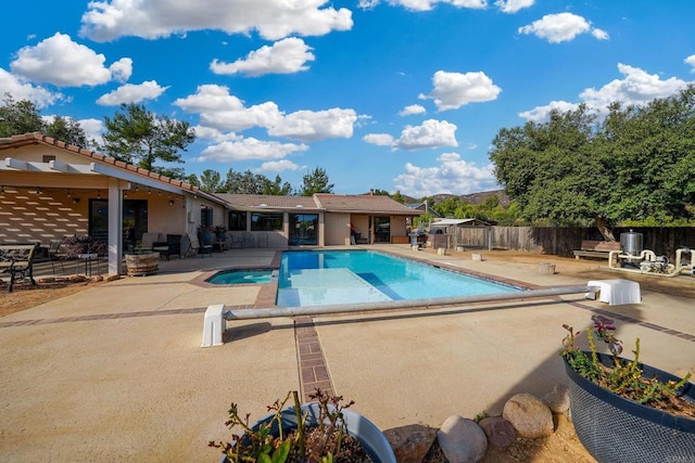 view of pool with a patio area and a diving board