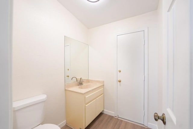 bathroom with vanity, hardwood / wood-style floors, and toilet