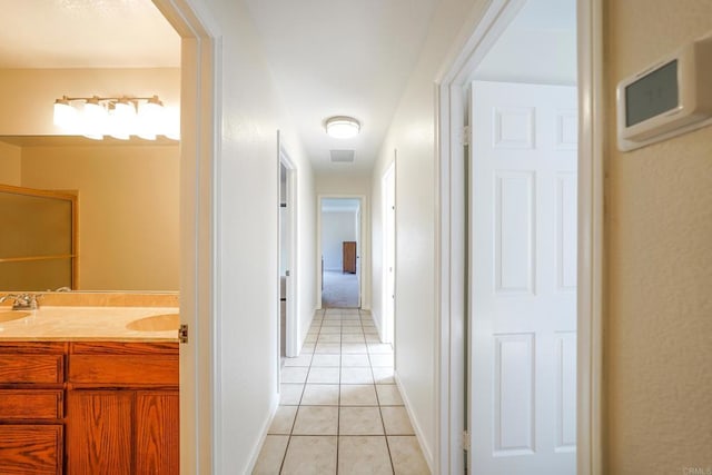 hallway featuring sink and light tile patterned floors