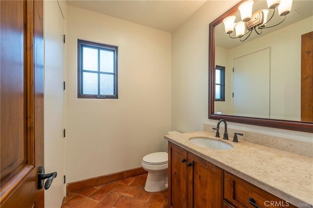 bathroom featuring toilet, vanity, a notable chandelier, and tile patterned flooring