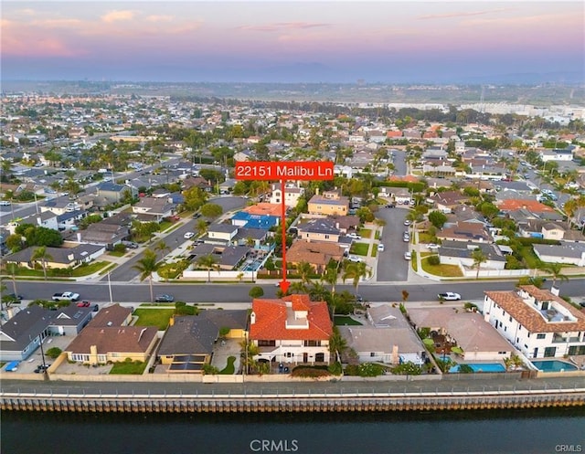 aerial view at dusk featuring a water view